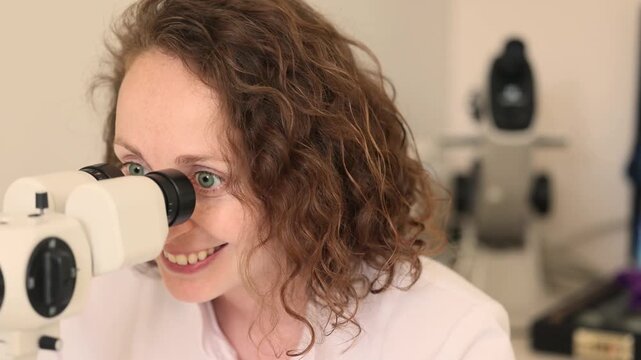 Woman looks through slit lamp during vision exam demonstration