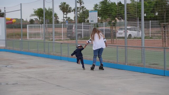 Child Teaching Mother to Roller Skate at Outdoor Sports Court