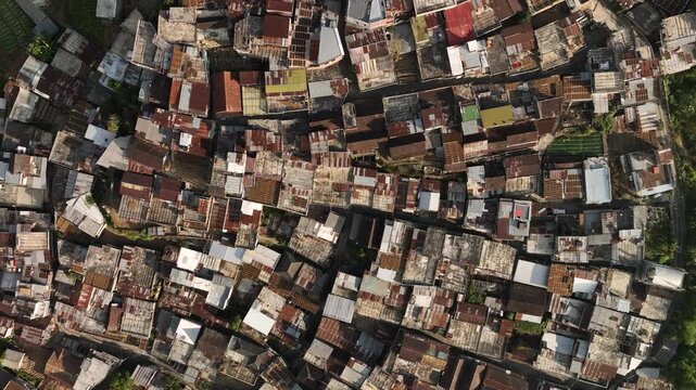 Aerial view of the dense rooftops of Kruwisan Village nestled in the mountainous landscape of Kledung, Central Java, Indonesia.