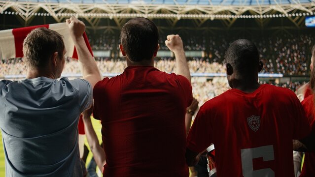 Diverse crowd cheers during live football match in stadium