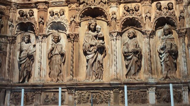 Ornate terracotta relief depicting the Madonna and Child flanked by saints and other religious figures in San Geminiano Cathedral of Modena in italy