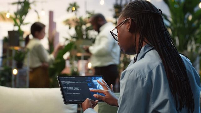 Businesswoman uses an AI dashboard on a tablet touchscreen in a rooftop lounge, reviewing digital information and testing AI tools for a project.