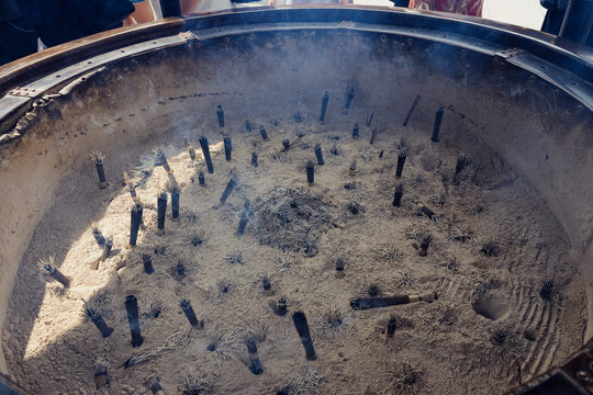 Incense sticks burning in a large metal censer at Senso-ji Temple in Asakusa, Tokyo, Japan, as part of a traditional Buddhist ritual.