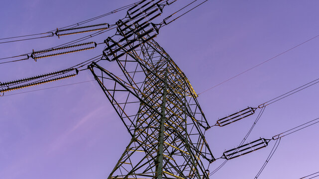 Energy grid infrastructure with high voltage pylons.