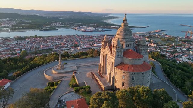 Scenic drone flight around the Basilica of Santa Luzia at dawn overlooking Viana do Castelo city and river, Portugal. Orbit parallax shot