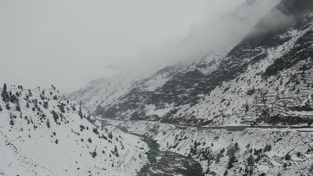 Aerial view of Naran Kaghan valley with snow-covered mountains and a flowing river in KPK, Pakistan.