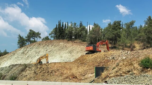Road Construction Diggers Working on Hillside Infrastructure Project