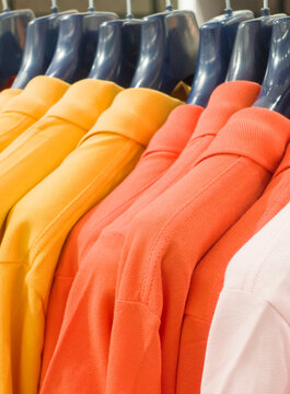 Colorful clothes on hangers in a retail shop.
Colorful clothes on hangers, multicolored T-shirts in shop