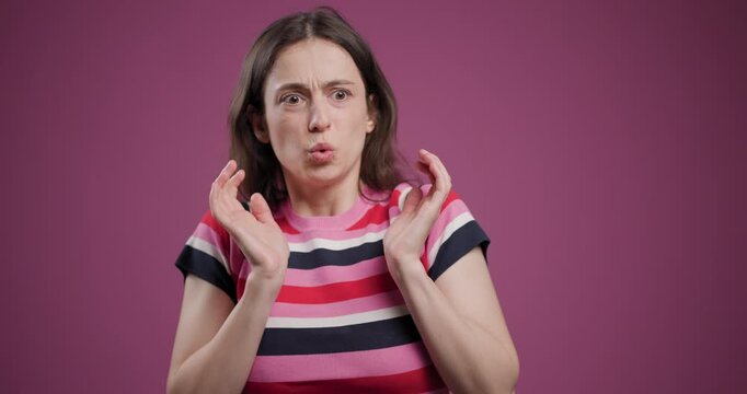 Young woman making a surprised expression on a pink background