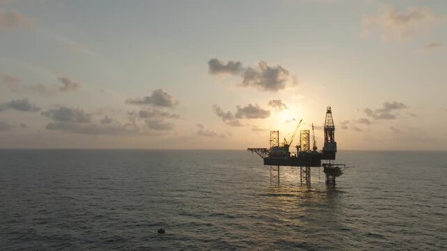 Offshore drilling rig - jack up and offshore platform during sunset for oil and gas exploration and production. 