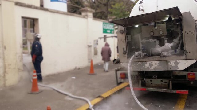 Blurred Worker Refilling Medical Oxygen Tank From Truck At Hospital  