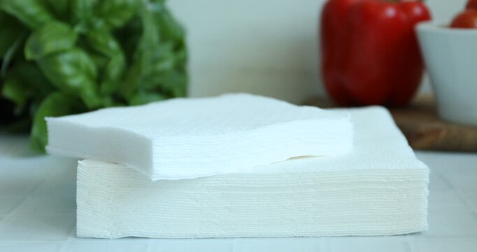 Woman taking paper tissues at white tiled table, closeup