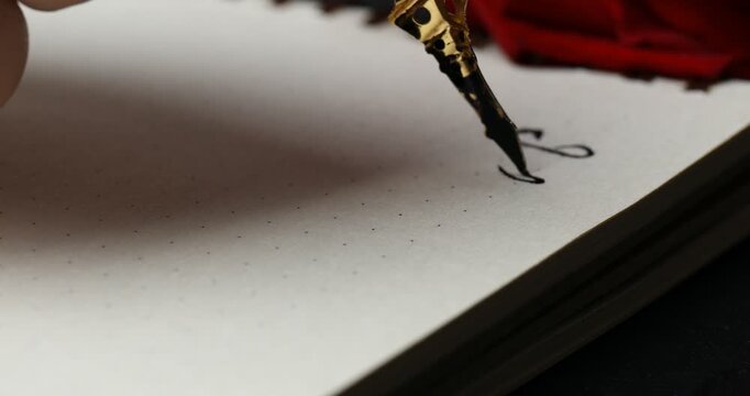 Woman writing phrase I Love You in notebook at table, closeup