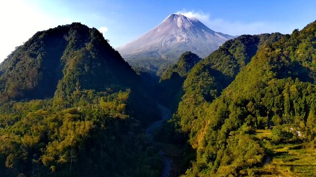 Aerial view of Nawang Jagad and Mount Merapi with lush green hills and volcanic landscape in Kecamatan Pakem, Daerah Istimewa Yogya, Indonesia.