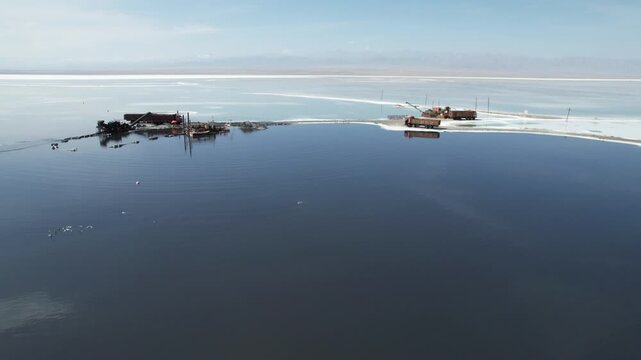 Aerial drone view of abandoned industrial equipment and rusted machinery on a causeway in Chaka Salt Lake, Qinghai, China