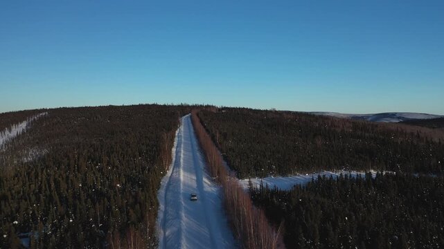Aerial View of a Lone Car Driving on a Straight Rural Highway Passing Through Alaskan Wilderness