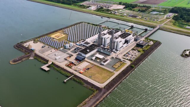 Aerial view of the Maxima power plant featuring solar panels and industrial infrastructure situated on a peninsula in Lelystad, Flevoland, Netherlands.
