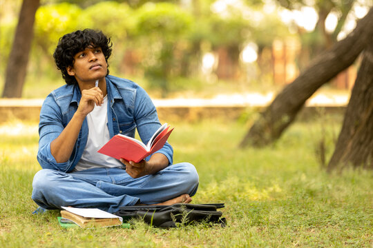 Indian male college student boy studying at park