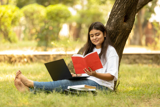 Indian college student young girl studying at park
