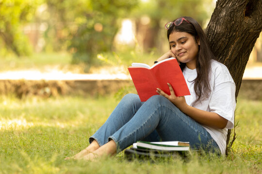 Indian college student young girl studying at park