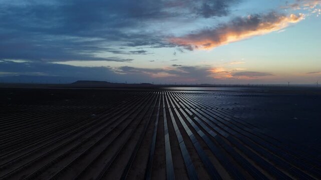 Rows of solar panels under the sunset sky