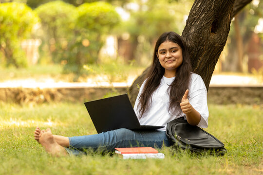 Indian college student young girl studying at park