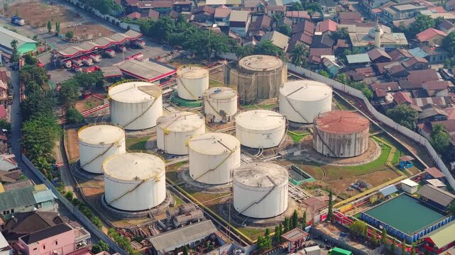 Aerial view of PT. Pertamina TBBM Samarinda fuel storage tanks surrounded by urban residential buildings in Samarinda, East Kalimantan, Indonesia.