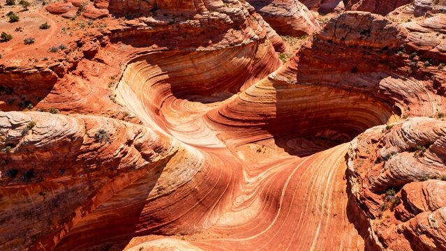 Aerial view of swirling red sandstone formations in a desert canyon