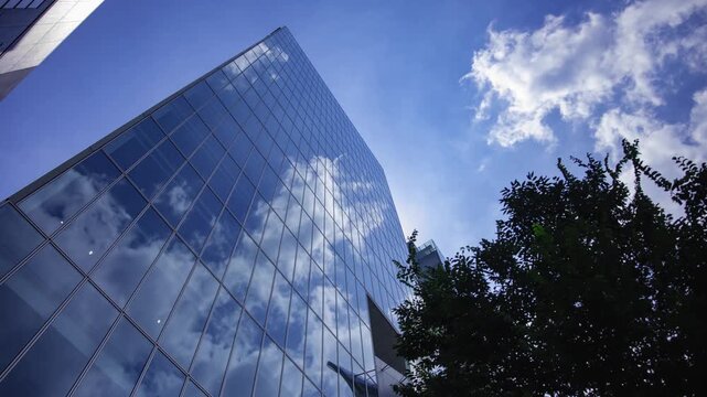 A timelapse of cloud reflecting the office building sunny day wide shot tilt
