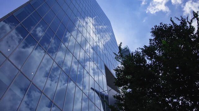 A timelapse of cloud reflecting the office building sunny day wide shot panning