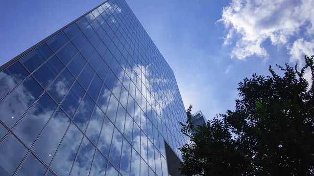 A timelapse of cloud reflecting the office building sunny day wide shot zoom