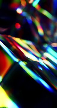 Light reflecting glass in brilliant saturated colors. Lighting through a prism cube creating a visual of a rainbow effect of light refraction. Dark geometric abstract background on black. Loop.