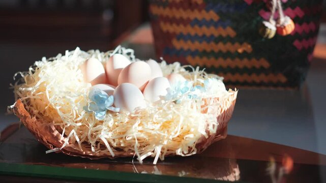 Easter nest with eggs and shredded paper on wooden surface