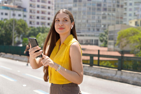 Portrait of Brazilian university student listening music with her earphones looking away in Sao Paulo, Brazil