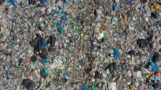 Aerial view of a large landfill site filled with various types of plastic waste, debris, and discarded materials in Russia.