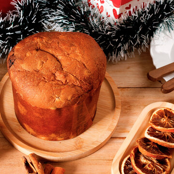 Traditional Christmas panettone filled with candied fruit and raisins, on a decorated table.
