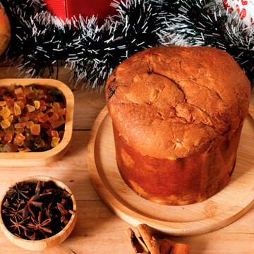 Classic panettone in a Christmas setting on a decorated rustic wooden table.