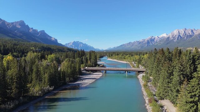 Vast aerial view of Bow River winding through the Canadian Rockies. Canmore, Alberta, Canada. Canmore Pedestrian Bridge.
