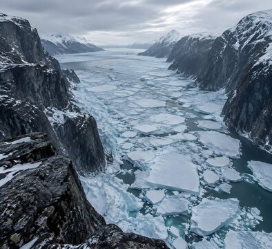 Frozen fjord filled with broken pack ice and pressure ridges locked between dark rock walls