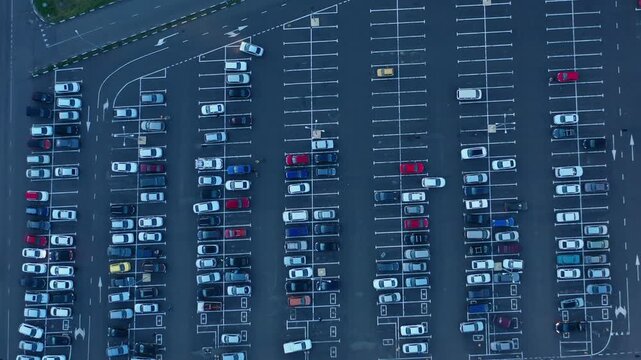 Aerial view of a large parking lot filled with many cars parked in orderly rows in Russia.