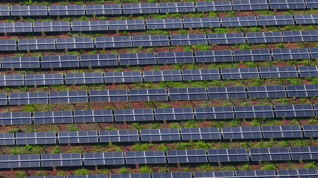 Aerial view of rows of solar panels installed in an industrial field in Nera Montoro, Umbria, Italy.