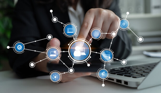 A business professional engages with digital network icons on a touchscreen device in a modern workspace, symbolizing technology-driven communication and connectivity. Crux