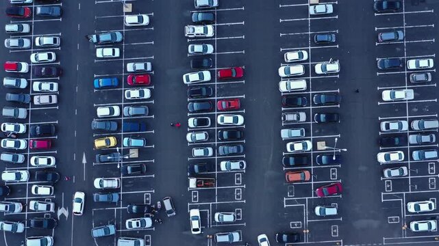 Aerial view of a busy parking lot filled with various cars parked in organized rows on asphalt in Russia.