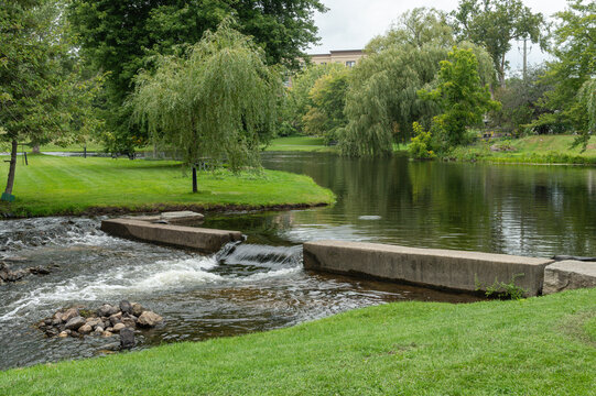 Scenic Riverside Park with Waterfall and Weeping Willow Trees