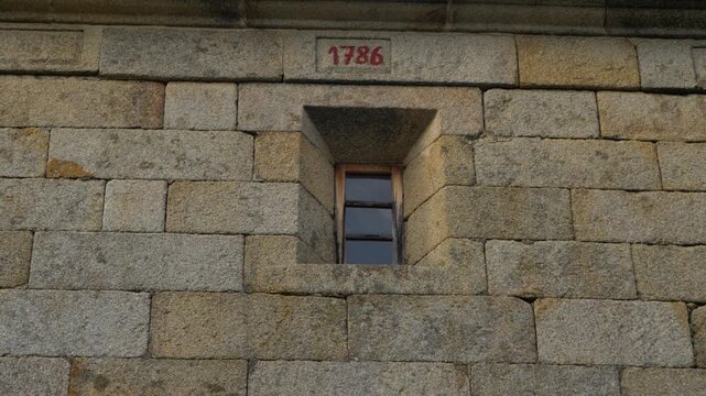 Small stone window of Nuestra Senora de los angeles church in Toen, Ourense, Galicia, Spain, closeup of 1786 year creation