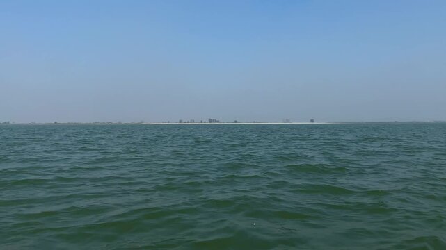 Sailing across the Padma river calm water towards Char island in the distance of Bangladesh