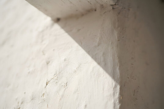 &bull;	Close-up macro view of a soft, sharp shadow line at the upper corner of a white whitewashed wall