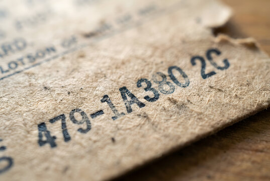 &bull;	Close-up macro view of a stamped serial number on an old cardboard train ticket