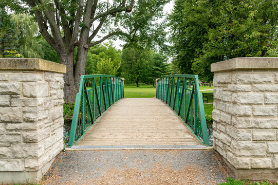 Scenic Green Footbridge Over a Creek in a Park