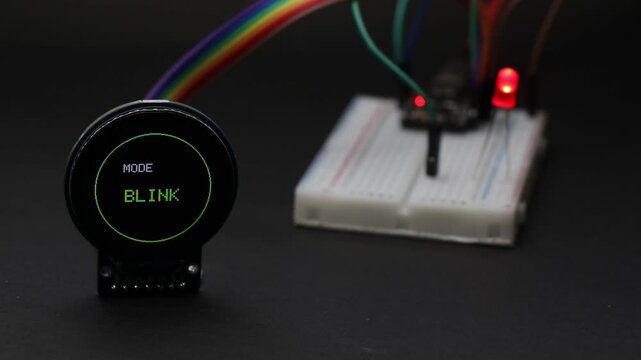 Round lcd display connected to breadboard with jumper cables showing led light patterns